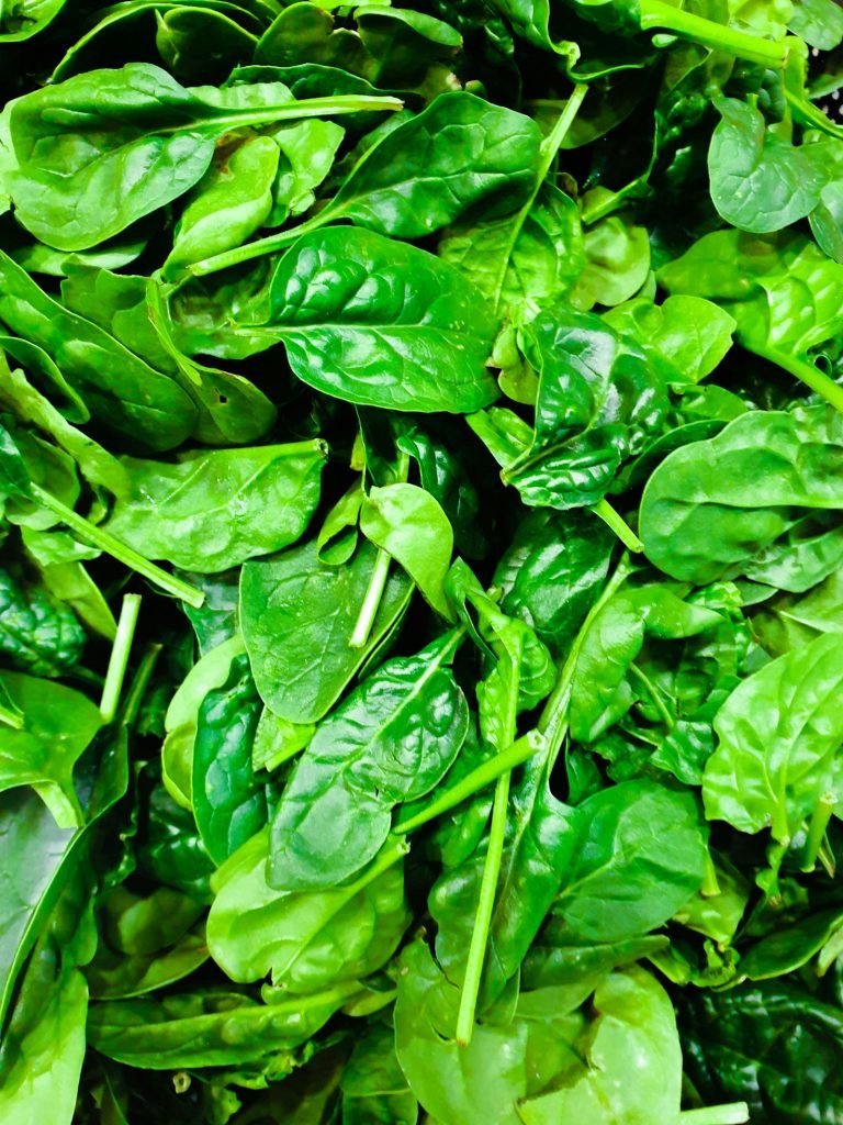 A pile of fresh green spinach leaves