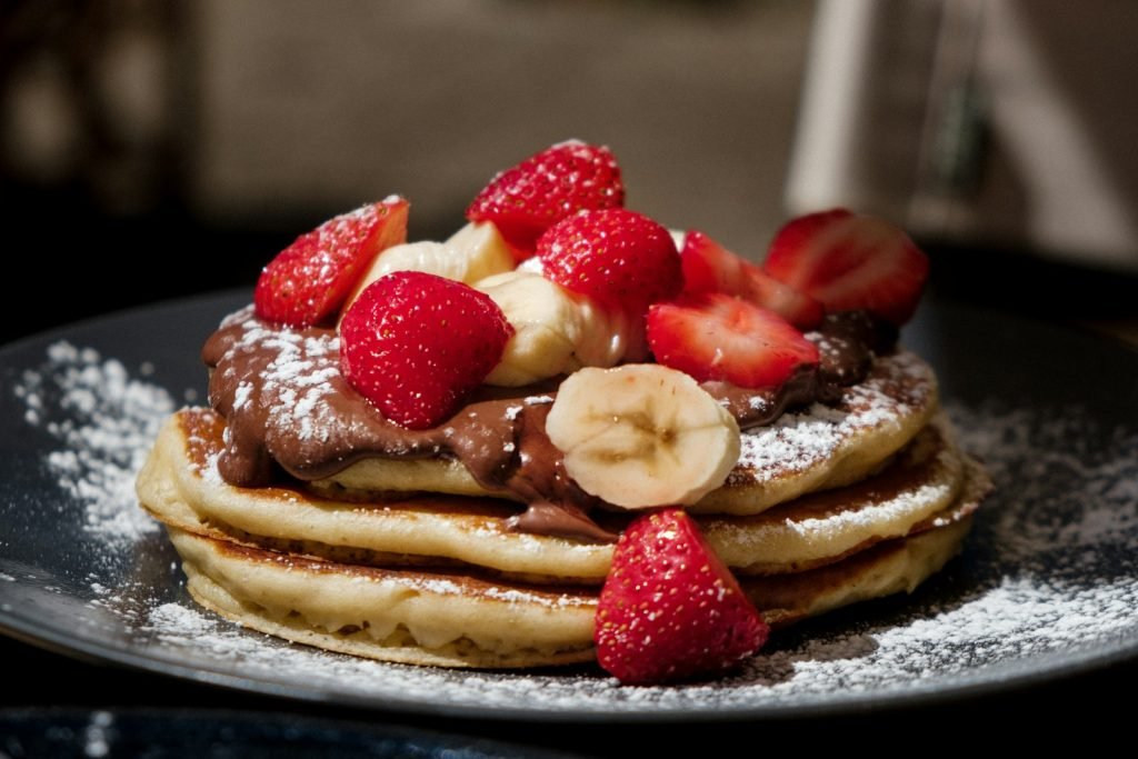 Pancakes topped with strawberries and blueberries
